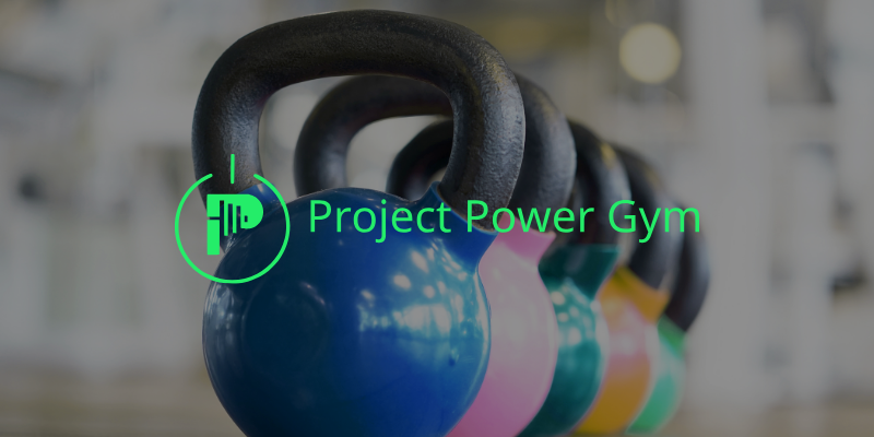 kettlebells lined up with project power gym's logo in the foreground
